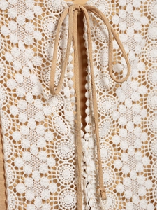 Close-up of crochet lace neckline with drawstring tie on summer bohemian dress