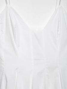 Détail de la robe blanche à col en V avec bretelles fines et texture du tissu coton