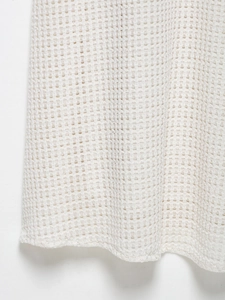 Macro detail of breathable ivory waffle knit fabric texture on this summer midi dress