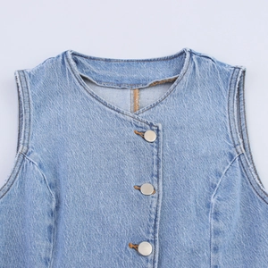 Détail d'un gilet en jean bleu clair avec boutons argentés et texture sergé