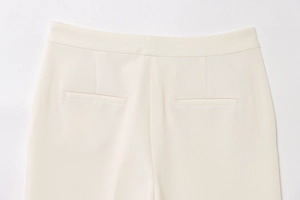 Detail of off-white trousers back waist featuring neat stitching and welt pockets