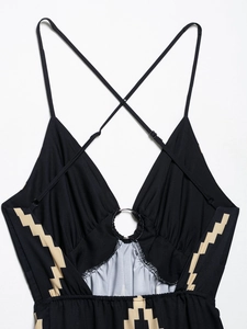 Detail of sexy deep V-neck black dress with metal ring connector and adjustable straps