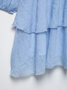 Gros plan sur les volants étagés bleu clair montrant la texture du tissu mousseline