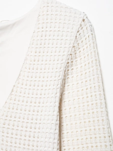 Detailed macro view of the white crochet hollow knit texture and inner lining layer