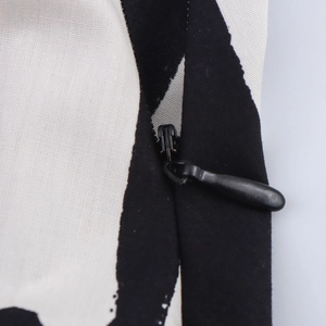 Close-up of invisible black zipper detail on black and white printed midi skirt fabric