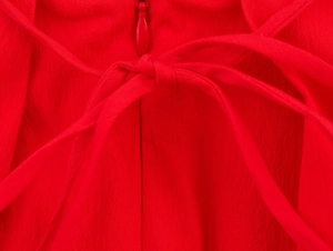 Détail de la robe midi rouge avec fermeture éclair invisible et nœud décoratif chic