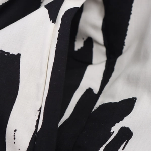 Close-up detail of woven fabric featuring artistic black and white abstract print