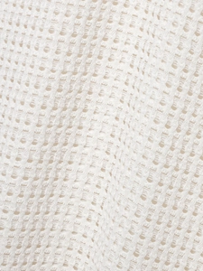 Macro shot of cream crochet knit fabric with breathable honeycomb mesh pattern