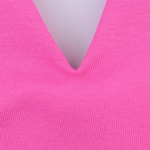 Close-up of V-neckline detail on a bright pink knitted summer halter dress fabric