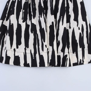Close-up of modern black and white abstract brushstroke print and stitched hem detail