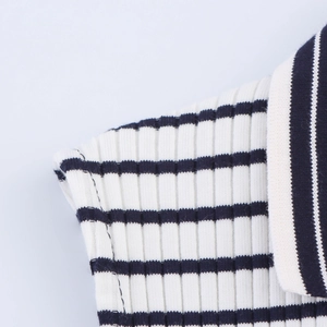 Detailed macro view of the ribbed knit polo collar and classic black and white stripes