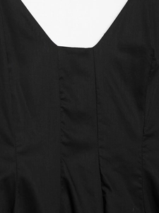 Détail des coutures et des lignes verticales sur une robe d'été noire à fines bretelles