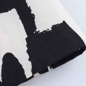 Detailed close-up of the black and white abstract print on the midi skirt fabric