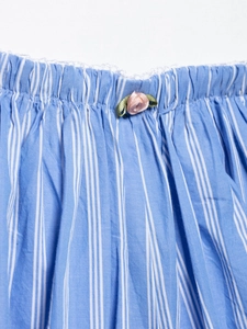 Détail du short à rayures bleues avec taille élastique, dentelle blanche et rose rose