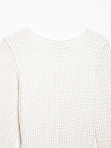Detail of white crochet knit midi dress featuring intricate hollow grid texture and crew neck
