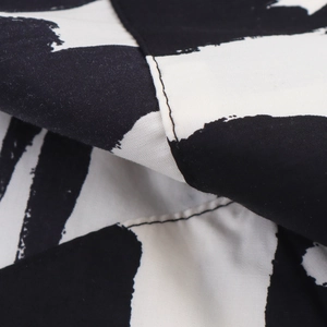 Close-up of high-quality double stitching on black and white abstract print fabric