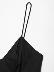 Détail des fines bretelles spaghetti et de la texture du tissu tissé de cette robe noire