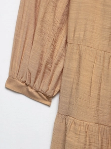 Detailed view of camel summer dress showing pleated fabric texture and tiered side design