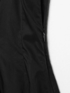 Gros plan sur la fermeture éclair invisible sur la couture d'une robe noire plissée