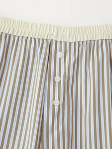 Detalle de pantalones cortos de rayas para hombre con cintura elástica y botones