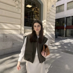 Women's olive green sleeveless vest with zipper and flap pocket in a street style look