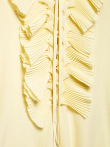 Detail of cream V-neck shirt featuring vertical pleated ruffles and lace-up drawstring design