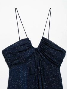 Detail of navy polka dot dress showing ruffled V-neckline and tie-front bodice design
