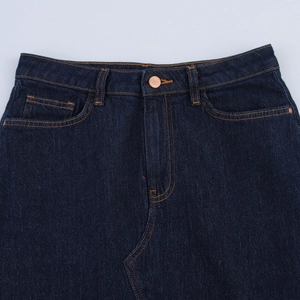 Gros plan détaillé du tissu denim indigo avec coutures contrastées et boutons en métal