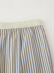 Detalle de los pantalones a rayas azules y marrones con cintura elástica crema