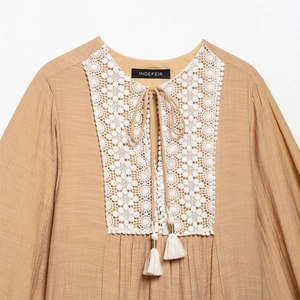 Boho light brown long sleeve top with white crochet lace and tassel ties on the neckline