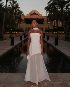 Close-up of white halter neck dress with mesh splicing and asymmetrical hem details