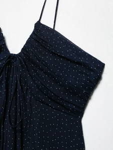Detail of polka dot dress featuring fine pleated texture and tie-up neckline design