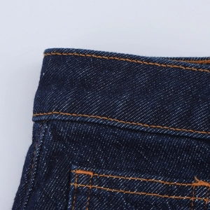 Gros plan sur la texture du denim bleu foncé avec des coutures orange précises