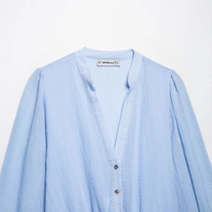 Robe d'été bleu clair en mousseline à col en V avec tissu texturé et boutons