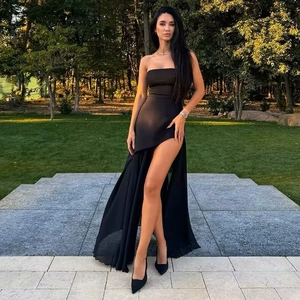Detail of elegant black strapless dress with high slit and layered mesh skirt overlay