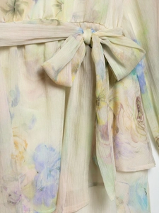 Detail of floral plissé chiffon dress with soft watercolor print and tied waist bow
