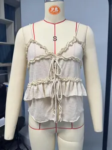 Détail de caraco en maille beige à volants avec lacets frontaux et col en V