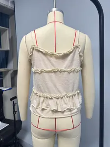 Détail du caraco en maille beige avec volants à trois niveaux et tissu texturé