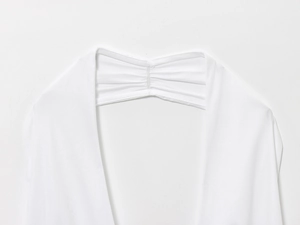 Close-up of refined gathered texture and stitching on a white summer dress bodice