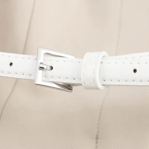 Close-up of white crocodile pattern faux leather belt with silver square buckle details