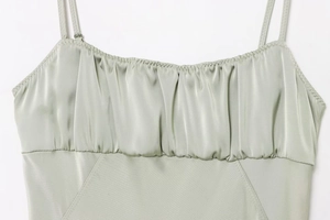 Detail view of the pleated chest design on this light green satin strap dress