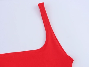 Détail de la robe en maille côtelée rouge montrant la fine bretelle et la couture