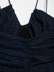 Detail of dark blue polka dot dress showing fine pleats and invisible zipper closure