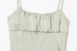 Detailed view of sage green satin camisole with spaghetti straps and pleated bust texture