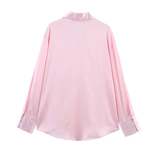 Rear view of the pale pink satin shirt showing smooth fabric texture and curved hemline