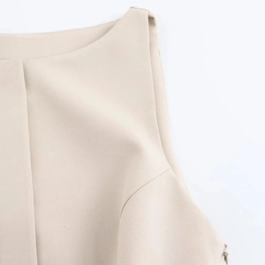 Detail of beige sleeveless dress showing twill fabric texture and hidden side zipper