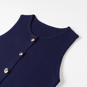 Close-up of navy knit vest with vertical ribbing and three polished gold metal buttons