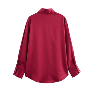 Detail view of the burgundy satin shirt back showing the smooth silk texture and curved hem