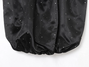 Détail du haut en satin noir avec strass argentés et finition élastique froncée