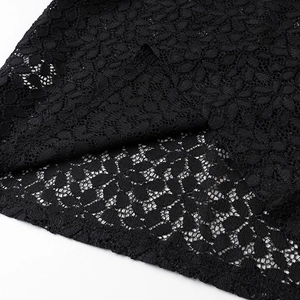 Close-up of black lace fabric with intricate floral hollow pattern and refined edges